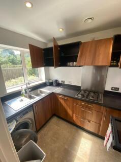 This well-lit kitchen features modern wooden ca...