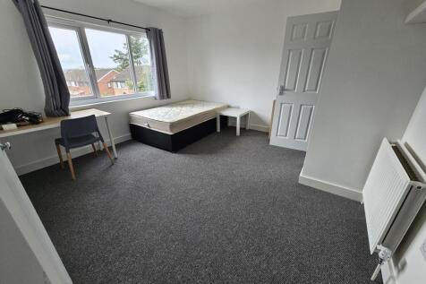 A spacious, bright bedroom featuring a large wi...