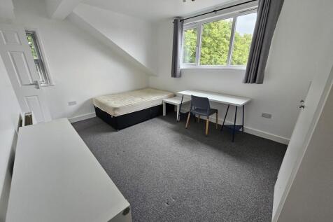 Bright and tidy bedroom featuring a large windo...