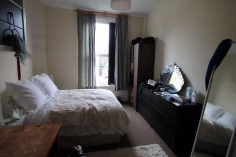 Bright and cozy master bedroom featuring a comf...