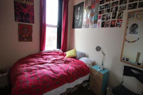 Cozy single bedroom featuring a bright window w...