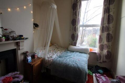 A cozy single bedroom featuring a comfortable b...