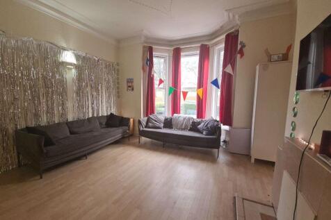 Bright and spacious living room featuring large...
