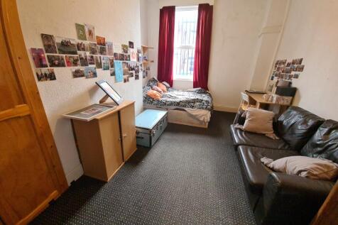 Cozy room featuring a comfortable bed with brig...