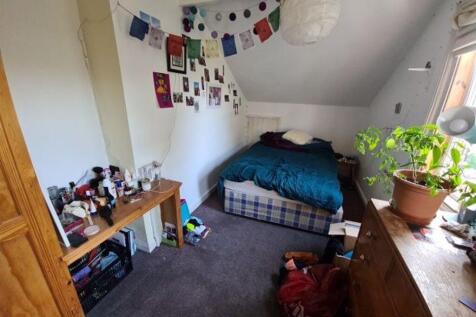 A cozy single bedroom featuring a comfortable b...