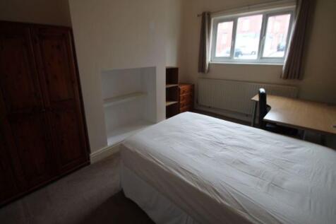 A cozy single bedroom featuring a comfortable b...
