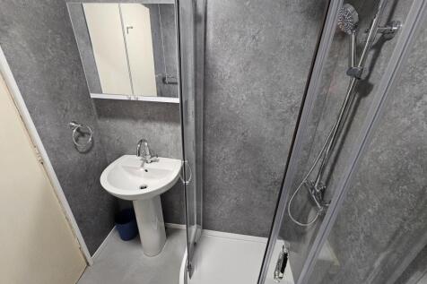 A modern bathroom suite featuring a shower encl...