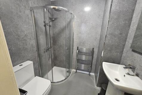 Modern bathroom featuring a spacious curved gla...