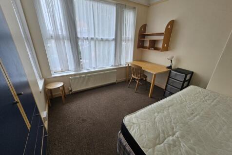 A bright and tidy single bedroom featuring a la...