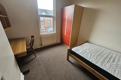 A neat and functional single bedroom featuring ...