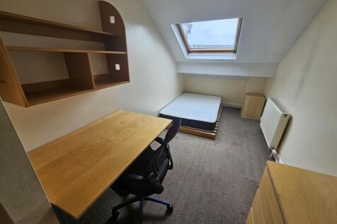 A compact, tidy single bedroom featuring a skyl...