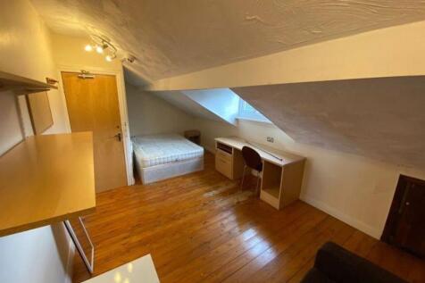 Cozy bedroom featuring a sloped ceiling, wooden...