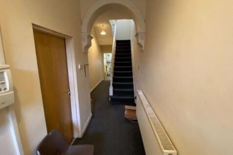A clean, narrow hallway with neutral walls and ...