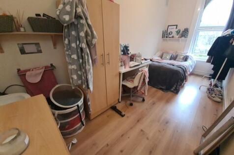 A cozy and well-lit single bedroom featuring a ...