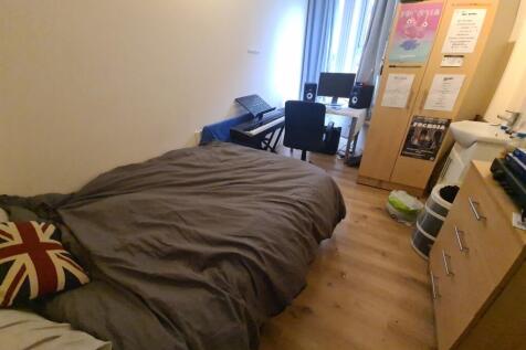 Cozy single bedroom featuring a comfortable bed...