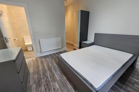 A clean and modern master bedroom featuring a l...