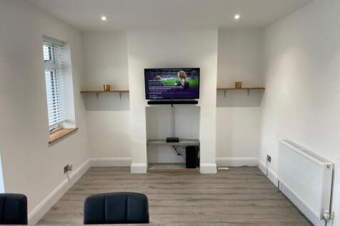 A modern, tidy living room featuring a mounted ...