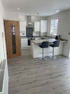 Bright and modern kitchen featuring sleek white...