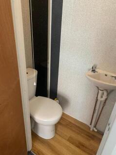 Compact and clean single toilet room featuring ...