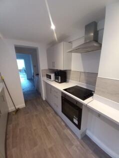 A modern and clean galley kitchen featuring sle...