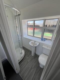 Bright and clean bathroom featuring a curved gl...