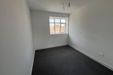 A clean, empty single bedroom with fresh white ...