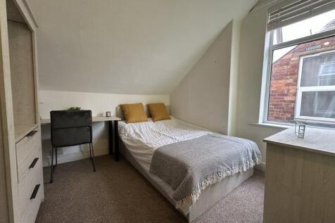 Cozy double bedroom featuring a comfortable bed...