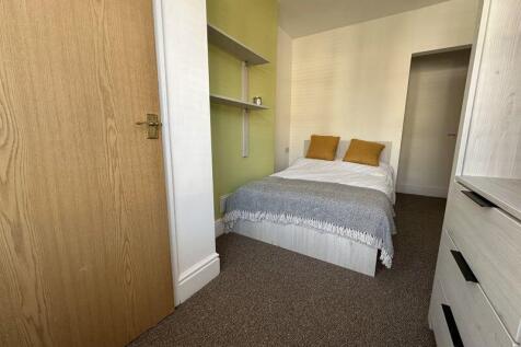 A cozy double bedroom featuring a neatly made b...
