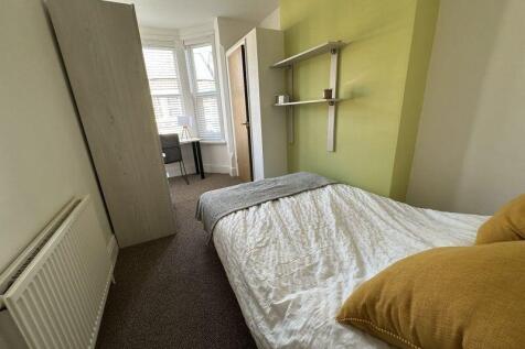 Bright and tidy single bedroom featuring a cozy...