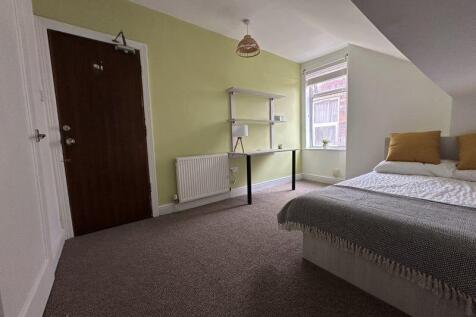 A cozy single bedroom featuring a comfortable b...