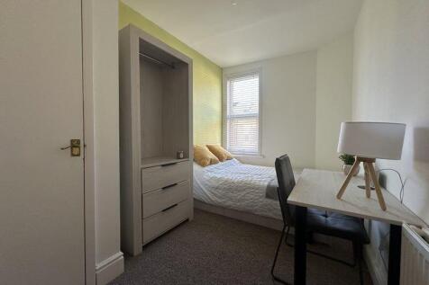 Cozy single bedroom featuring a comfortable bed...