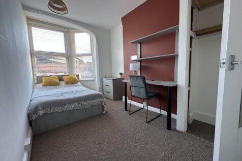 A bright double bedroom featuring a comfortable...