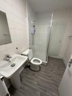 A clean and modern bathroom featuring a walk-in...