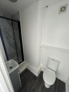 A compact, modern bathroom featuring a white to...