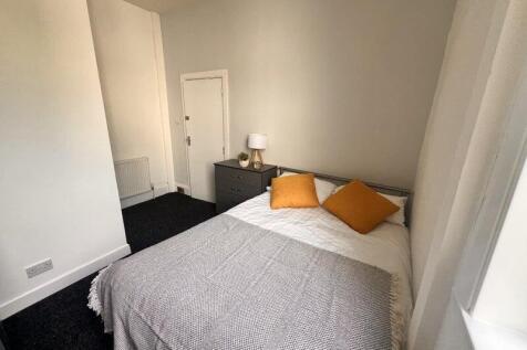 A cozy double bedroom featuring a neatly made b...