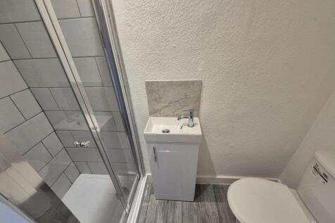 A clean and modern bathroom featuring a tiled s...