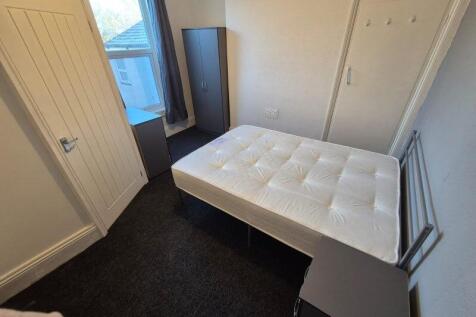 A tidy single bedroom featuring a comfortable m...