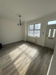 Bright and airy living room featuring large win...