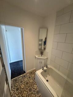 A bright and clean bathroom suite featuring a m...