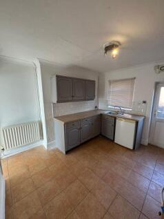 A compact kitchen featuring a practical L-shape...