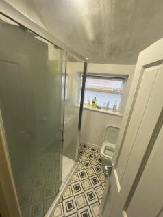 Bright bathroom featuring a modern shower enclo...