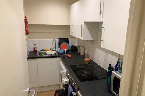 A compact kitchen equipped with essential appli...