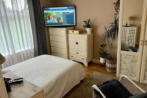 A cozy double bedroom featuring a large window ...