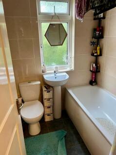 A bright and clean bathroom suite featuring a w...