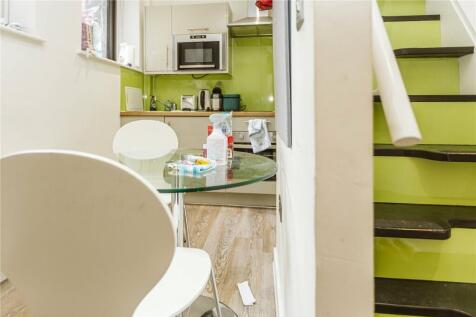 A bright and modern kitchen featuring clean whi...