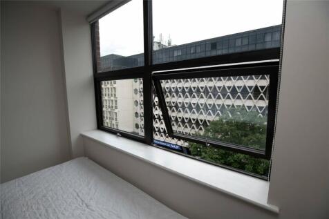 A compact room featuring a large window with a ...