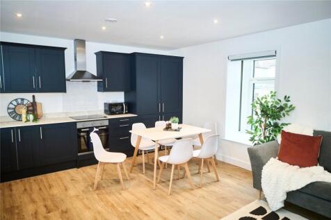 Modern open-plan kitchen with sleek black cabin...