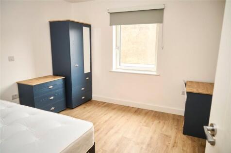 A clean and simple bedroom featuring light wood...