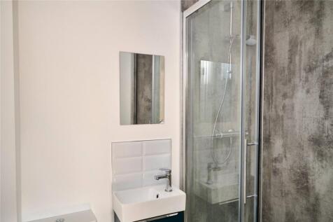 A modern bathroom featuring a clear glass showe...