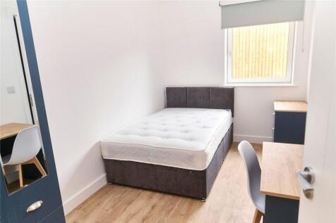 A bright and tidy single bedroom featuring a co...